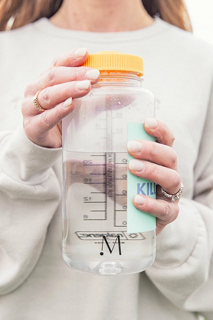 woman holding momco branded water bottle