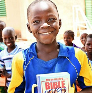 A young boy holding a kid's bible