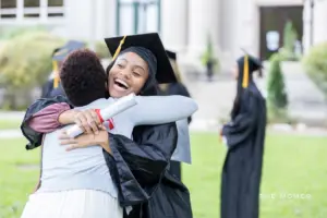 Mother hugging her adult daughter at graduation.